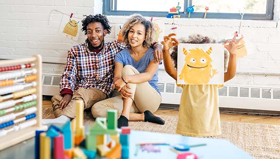 Family of three in the room filled with toys