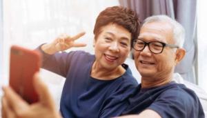 Senior Asian couple grandparents taking a selfie photo together at home