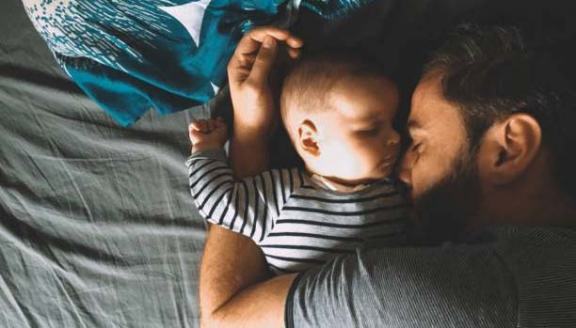 Father and son sleeping in bed