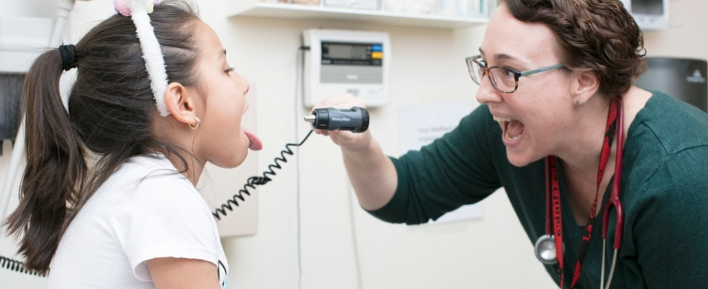 Dr. checking girl's throat